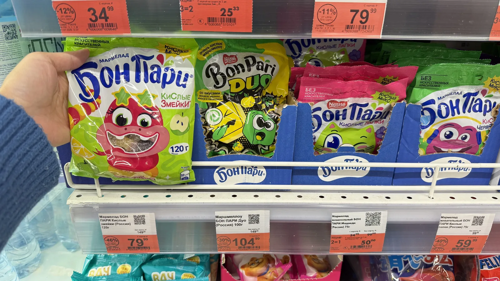 Una compradora toma una bolsa de golosinas de un estante de conveniencia — el momento de impulso para el que están hechas las gomitas de café
